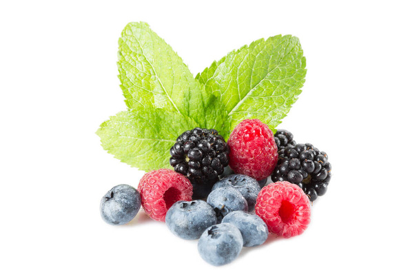 Mix of berries. Raspberries, blueberries and blackberries on a white background with leaves mint. Isolated. - Foto, afbeelding