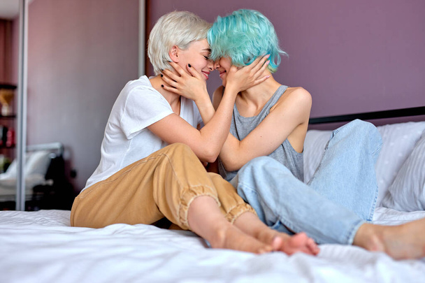 Awesome Caucasian Couple Sit On Bed At Home Hugging, Having Romantic Time Together - Foto, afbeelding