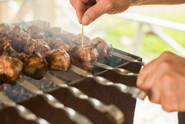 The cook prepares a shish kebab on the grill. BBQ party . Close-up. - Φωτογραφία, εικόνα