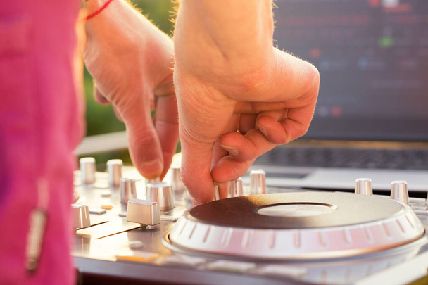 DJ miksowanie muzyki na świeżym powietrzu. Ręce DJ-a miksują dźwięk na panelu sterowania - Zdjęcie, obraz