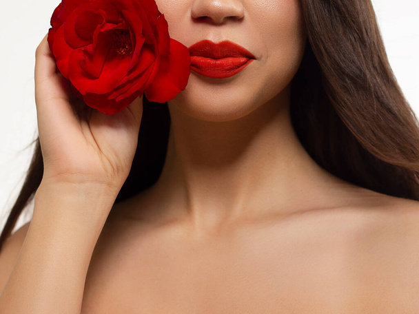 Half a beauty portrait with beautiful fashionable evening make-up with flowers, black jiggles on eyes and extremely long eyelashes. Red lipstick on the lips. Cosmetology and spa facial skin care - Foto, Imagem