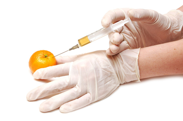 Mandarine kap egy narancssárga anyagot fecskendeznek a kezét kesztyű - Fotó, kép