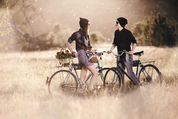Two beautiful hipsters standing outdoor in summer with white vintage fixed gear bicycle - Fotografie, Obrázek