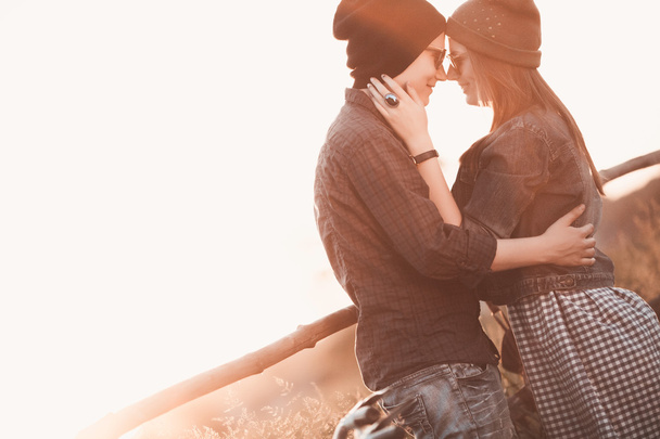 Young fashion hipster couple in love kissing and having passion in spring sunny weather - Fotó, kép