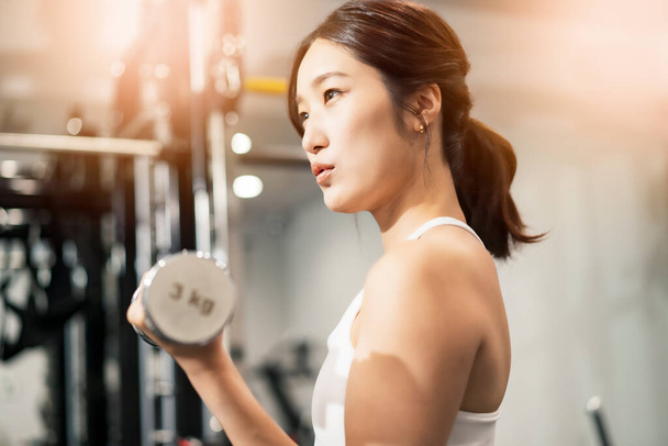 Asiatico giovane donna fare muscle training con manubri - Foto, immagini