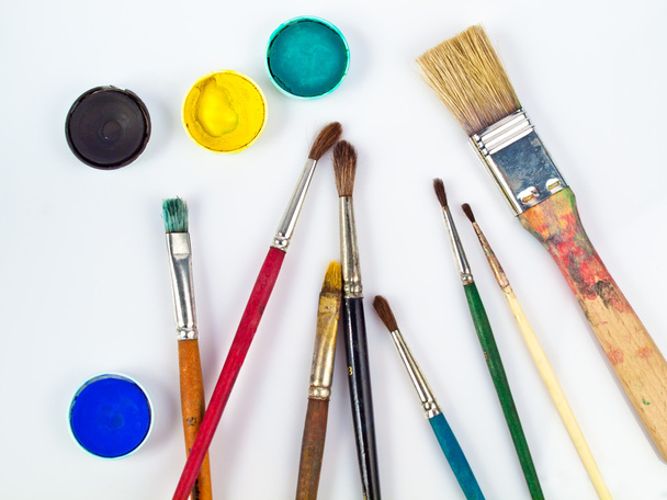 Paintbrushes and watercolors, art and craft equipment lying on a white table - Photo, Image