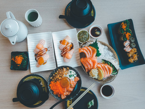 Japońskie jedzenie sashimi łosoś i ustawić różne rodzaje sushi z sałatką z wodorostów i gari (imbir) jest zdrowe jedzenie w prawym górnym rogu tablicy serwowania w japońskiej restauracji - Zdjęcie, obraz