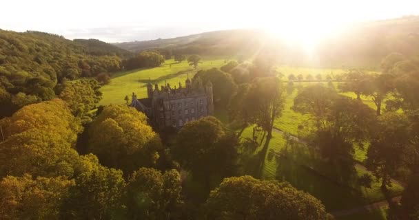 Aerial view of Glenarm Castle and sun throught trees in Ireland  - Filmmaterial, Video
