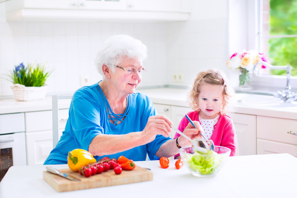 γιαγιά και το κοριτσάκι που κάνει σαλάτα - Φωτογραφία, εικόνα