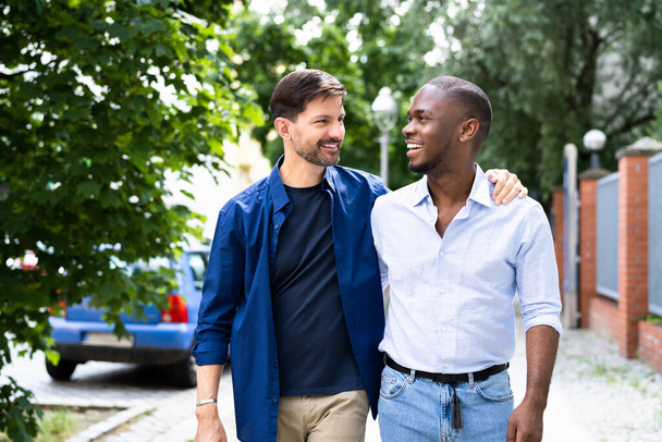 Gay Couple Dating In Jeans. Walking On Street In City - Zdjęcie, obraz