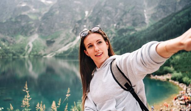 Travel influencers. Beautiful young woman blogger with smartphone on summer nature background. Mountain rock landscape. Traveling and freelancing, modern lifestyle concept - Photo, Image