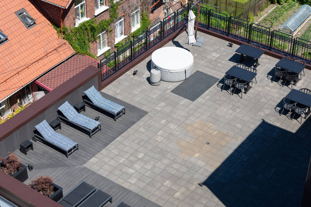 Sun loungers and a sofa on the designer roof terrace of the house. The concept of recreation and entertainment. - Фото, зображення