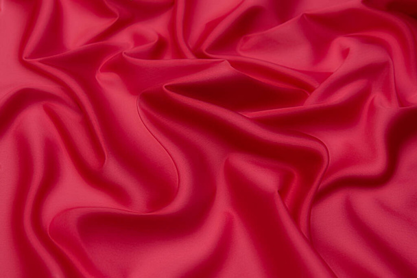 Detailní textura přírodní červené nebo růžové tkaniny nebo látky stejné barvy. Textilní struktura z přírodní bavlny, hedvábí nebo vlny nebo lněného textilního materiálu. Červené a oranžové plátno pozadí. - Fotografie, Obrázek