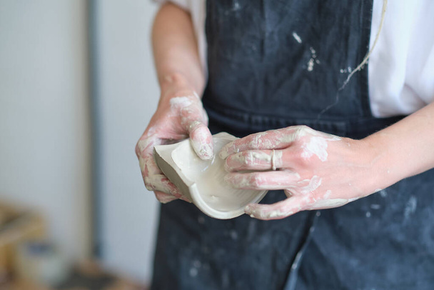 hands of the ceramist shows the cut of the bowl. master demonstrates the quality of his work - Photo, Image