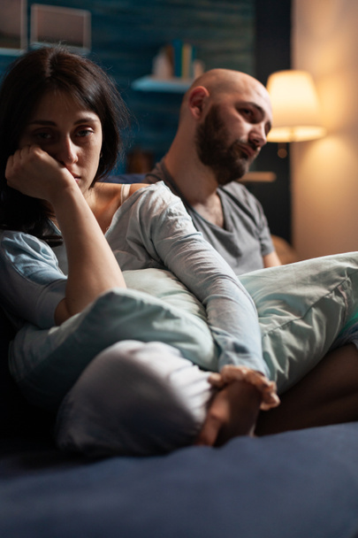 Zranitelný, vyděšený, deprimovaný, frustrovaný mladý pár sedící na gauči - Fotografie, Obrázek