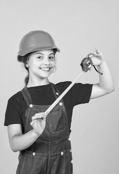 length. construction worker with tape measure. Cute kid as a construction worker. kid repairing home. happy childhood. self-retracting metal tape measure. Little girl using a measuring tape - Fotoğraf, Görsel