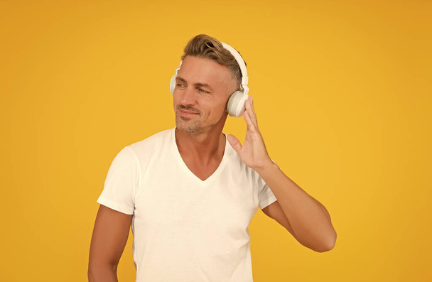 Get a language confident. Middle-aged man listen to headphones. English school. Foreign language courses. Audio lesson. Modern education. New technology for learning - Foto, Imagem