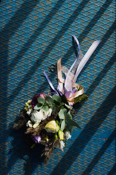 a beautiful bouquet of the bride lies next to the wedding rings - Fotoğraf, Görsel