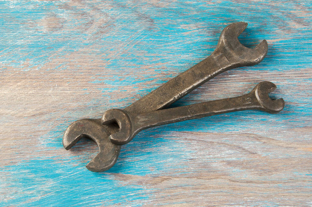 Set aus zwei Vintage-Bronzeschlüssel auf schäbigem blauem Holzhintergrund. Kopierraum für Text. - Foto, Bild