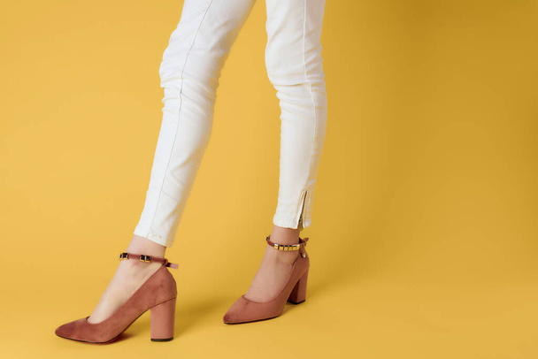 female legs in white pants shoes posing close-up isolated background - Fotó, kép