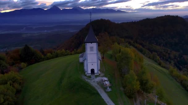 Vuoristomaisema kukkuloilla ja Saint Tomasin kirkko Savan laakson yläosassa Sloveniassa, ilmakuva - Materiaali, video