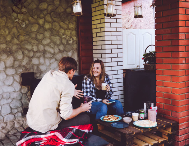 Jovem e cara se divertir conversando enquanto sentado no quintal e beber café - Foto, Imagem