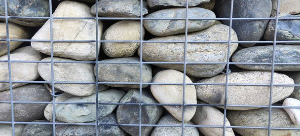 paredes de roca de río en jaulas de metal. Foto de alta calidad - Foto, Imagen