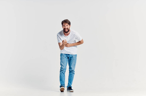 man in white t-shirt in movement  on  light background. High quality photo - Fotoğraf, Görsel