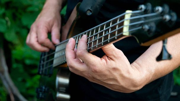 Un hombre tocando una melodía en una guitarra. Primer plano - Foto, Imagen