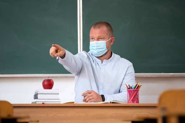  Teacher with mask in the classroom. Social distanting and classroom safety during coronavirus epidemic - Photo, image