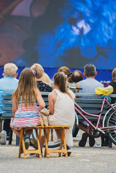Open-air cinema. People watching a movie on a summer cinema screen. - Фото, изображение