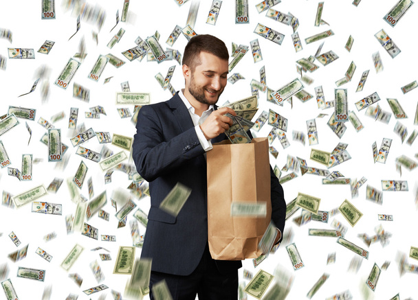 Geschäftsmann steckt Dollar in die Papiertüte - Foto, Bild