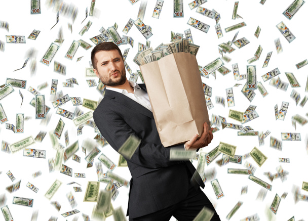 Mann mit Papiertüte im Dollarregen - Foto, Bild