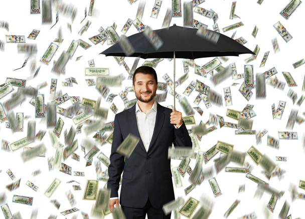 людина з парасолькою, що стоїть під грошовим дощем
 - Фото, зображення