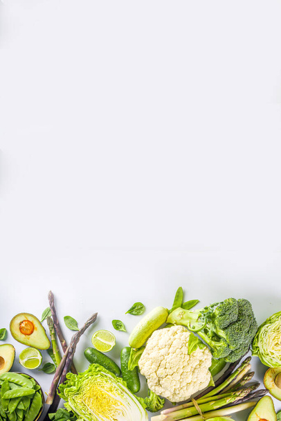 Dieta saludable Fondo de alimentos de primavera. Surtido de verduras frescas verdes orgánicas crudas - brócoli, coliflor, calabacín, pepinos, espárragos, espinacas, aguacate, col sobre fondo blanco - Foto, imagen
