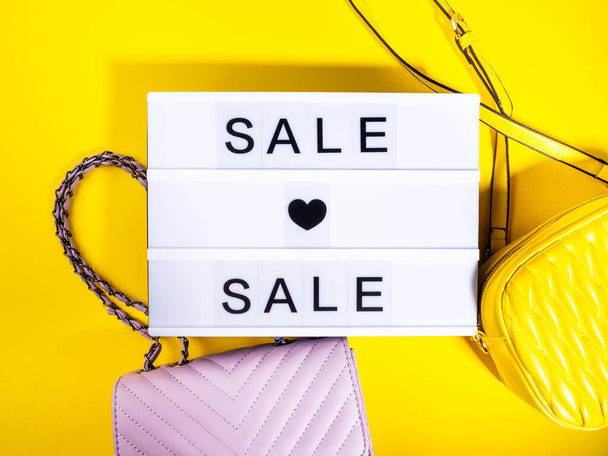 Fashion πώληση έννοια με lightbox κείμενο και δερμάτινες τσάντες σε κίτρινο - Φωτογραφία, εικόνα