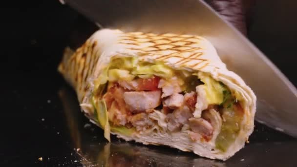 Professional chef is making shawarma at fast food cafe, close-up. He is finishing and wrapping the roll. - Footage, Video