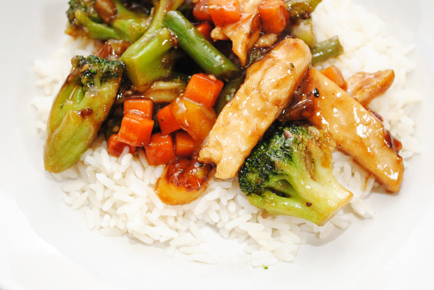 Revuelva el pollo frito y las verduras servidas sobre arroz blanco
 - Foto, imagen