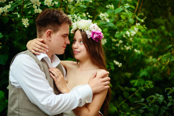 Happy wedding couple in flowers - Zdjęcie, obraz