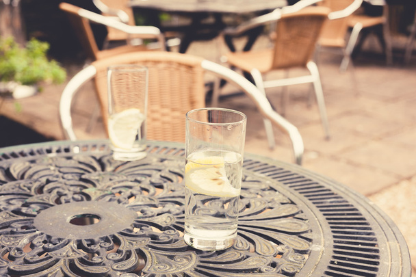 Two glasses on a table in garden - Fotoğraf, Görsel