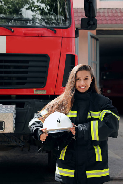Portrait of firefighter in uniform with helmet near fire truck outdoors - Fotoğraf, Görsel