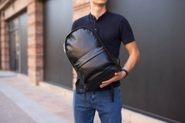 Man holding and demonstrate his new black leather backpack - Foto, immagini