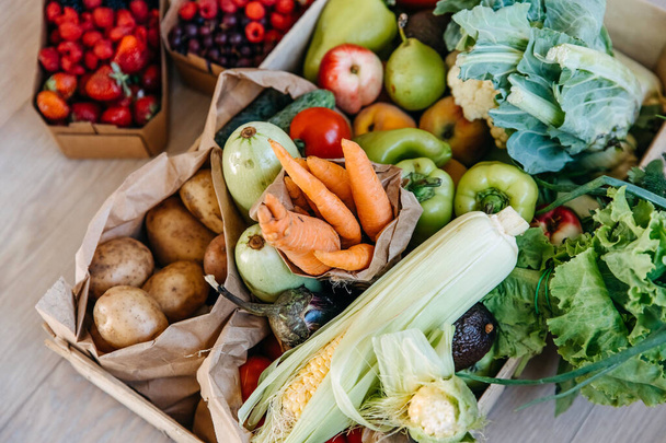様々な有機野菜、果物やベリーでいっぱいの箱の閉鎖。食品配送のコンセプト. - 写真・画像