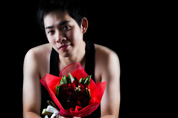 Asiatique garçon avec rouge bouquet dans sombre fond
 - Photo, image