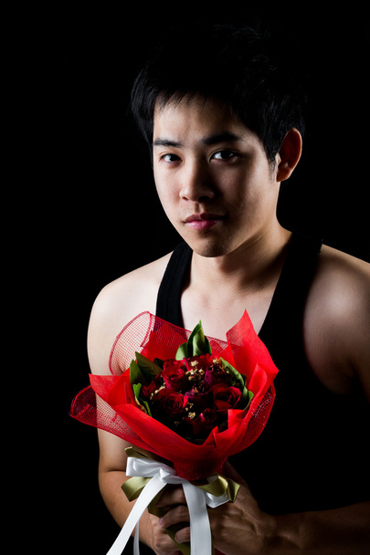 asiatico ragazzo con rosso bouquet in scuro sfondo
 - Foto, immagini