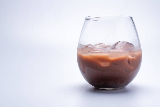 Water, cocoa, iced in a round transparent glass on a white background. - Zdjęcie, obraz