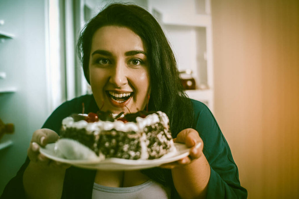 Plus Size Model Smiles Holding Plate With Chocolate Cake - Fotó, kép