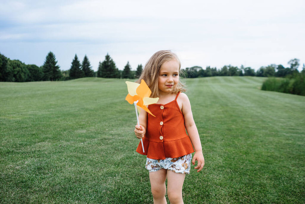 Šťastné malé dítě s větrníkem hrát venku - Fotografie, Obrázek