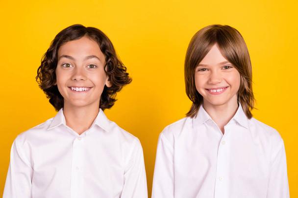 Photo of two candid glad schoolboys shiny white smile wear white shirt isolated yellow color background - Φωτογραφία, εικόνα