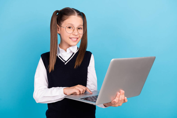Фото позитивной веселой счастливой девушки держаться за руки компьютер улыбка умный изолированный на синем фоне цвета. - Фото, изображение